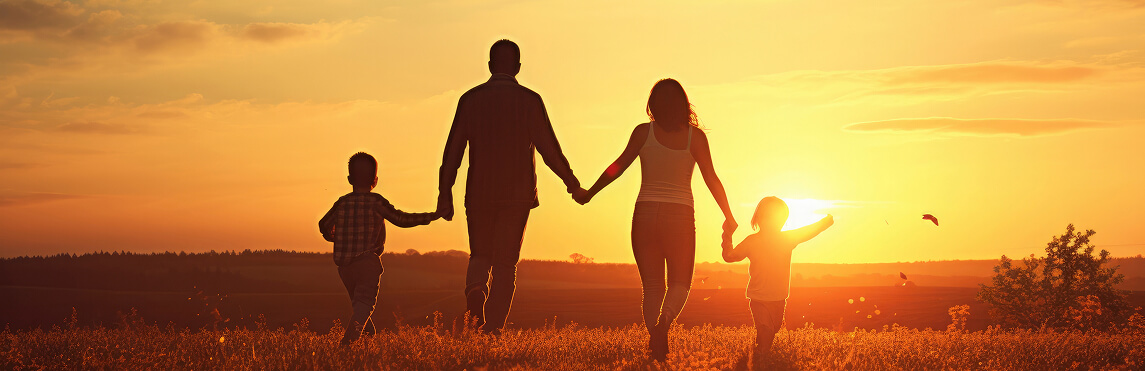 Foto da visão de costas com família seguindo em direção ao por do sol