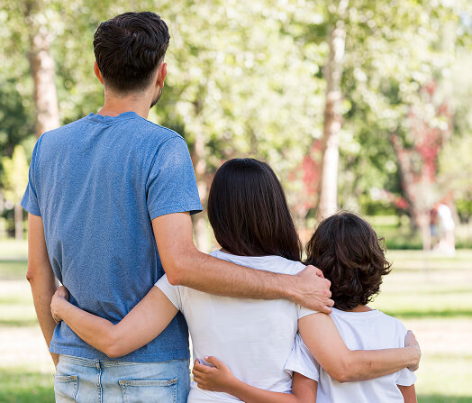 Imagem de trás de uma família abraçada