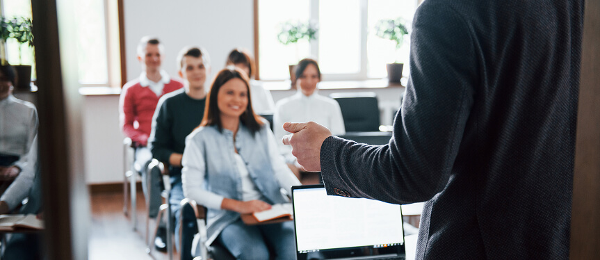 Pessoas sentadas em uma sala assistindo uma aula