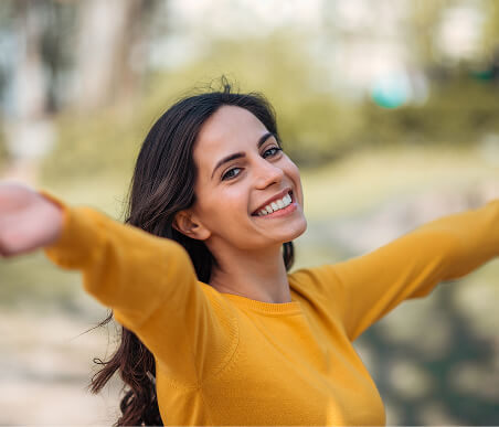 Close em mulher feliz com os braços abertos sorrindo para a câmera