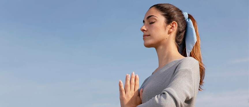 Vista lateral de uma mulher meditando na natureza