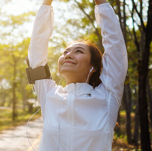 Uma jovem mulher alongando os braços antes de correr no parque